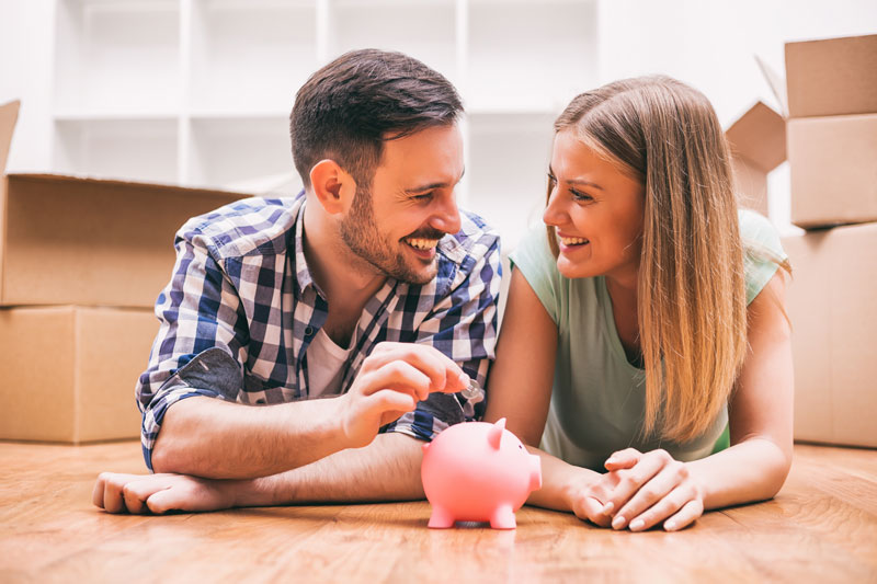couple placing money into a piggy bank